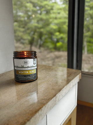 9oz Amber Jar Candles on a table in front of an indoor yule tree
