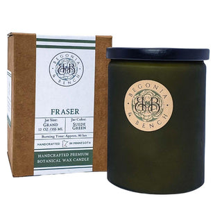 A "Fraser™ - 12oz Finely Crafted Scented Candle by Begonia & Bench®" is displayed next to its brown and green packaging box. The jar is suede green with a lid, and the label mentions it is handcrafted in Minnesota, containing 12 oz of botanical wax. The burn time for this fall candle is approximately 90 hours.