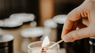 lighting a candle with a match