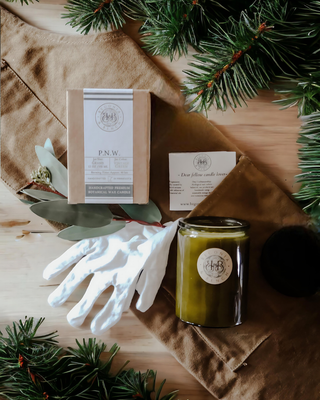 Finely Crafted Begonia & Bench Candles next to a white cotton glove