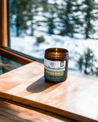 9oz Amber Jar Candles on a table in front of an indoor yule tree