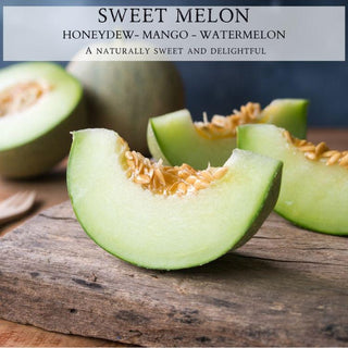 Close-up image featuring three slices of green sweet melon on a wooden surface, with the melon's seeds visible in each slice. In the background, a whole melon and a small spoon are placed beside a Begonia & Bench® Sweet Melon 9oz. Amber Jar Candle. Text at the top reads: "SWEET MELON HONEYDEW - MANGO - WATERMELON A naturally sweet and delightful scent.