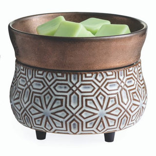 The Classic 2-in-1 Candle Warmer is a decorative piece made from brown and white ceramic, featuring geometric patterns and four small legs. It includes a top compartment for holding fragrance wax melts, while the lower portion showcases intricate, symmetrical floral motifs that add an elegant touch to any space.
