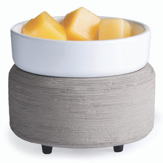 A Classic 2-in-1 Candle Warmer with a white ceramic bowl that holds fragrance wax melts is positioned on a textured gray concrete base with small black feet. The wax cubes are organized neatly within the bowl, contributing to its minimalist and modern design.