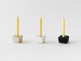A DAIYO Rice Wax Candle Gift Box sits elegantly in a square holder, offering a serene and refined ambiance to any space.